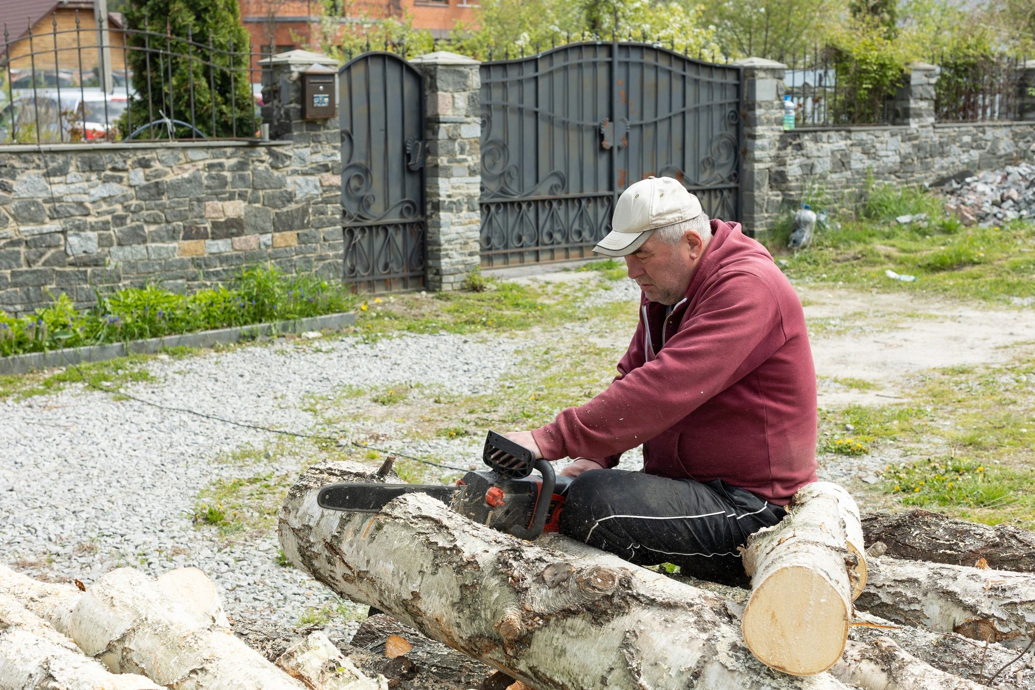 Worker cutting logs during tree service cleanup